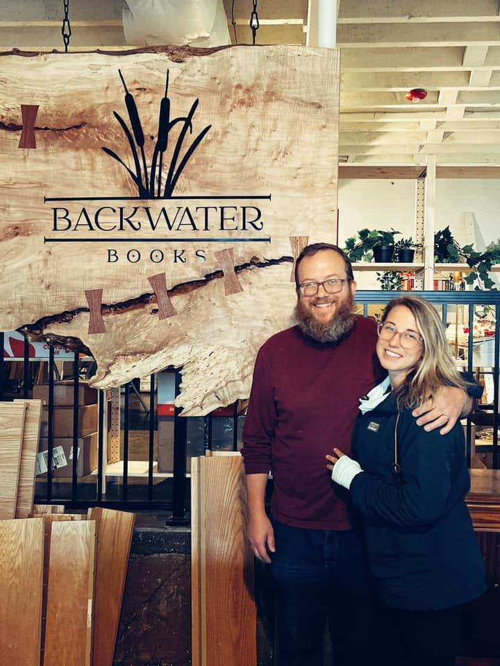 New owners Matt and Allison Krist standing in front of their Backwater Books shop sign.